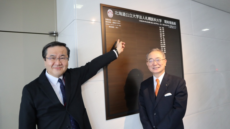 寄附者銘板の前で記念撮影